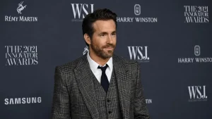 Ryan Reynolds dressed in a sharp grey houndstooth three-piece suit and navy tie at the 2021 WSJ Innovator Awards, an event that recognized the entrepreneurial genius behind Ryan Reynolds net worth and business achievements.