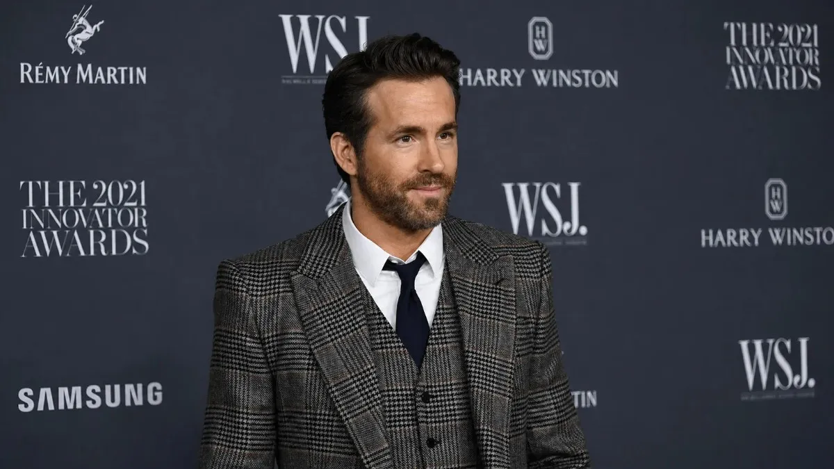 Ryan Reynolds dressed in a sharp grey houndstooth three-piece suit and navy tie at the 2021 WSJ Innovator Awards, an event that recognized the entrepreneurial genius behind Ryan Reynolds net worth and business achievements.