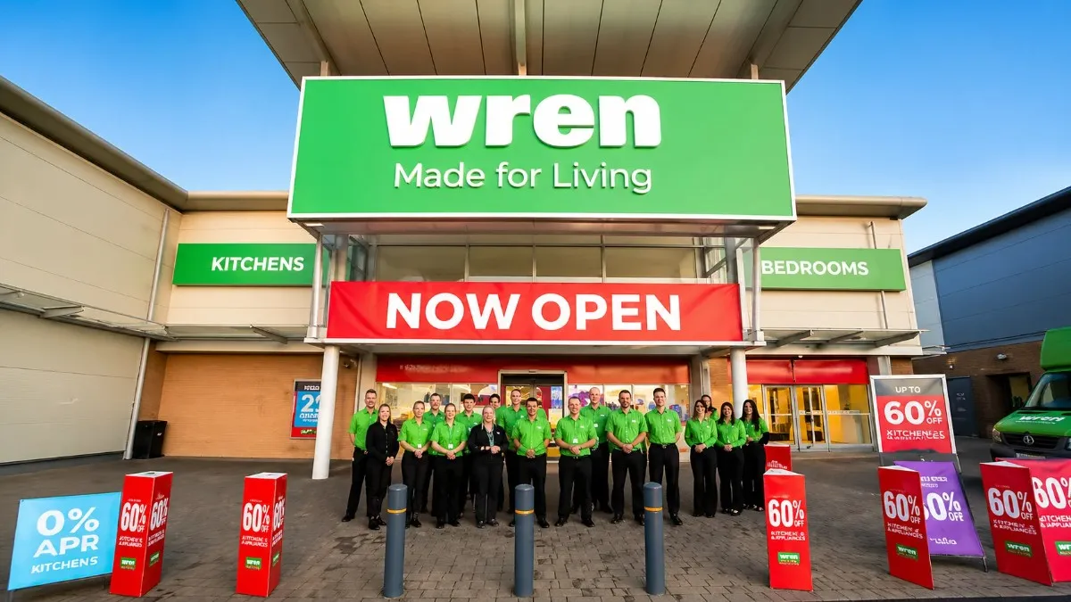 Wren Kitchens Chapter 7 storefront grand opening with team standing under NOW OPEN banner and promotional kitchen sale signs.