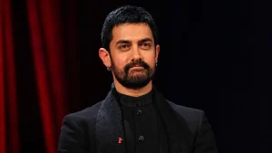 Aamir Khan net worth wearing a navy blazer over a black Nehru-collar outfit with a red Berlinale bear pin on his lapel at the Berlin International Film Festival