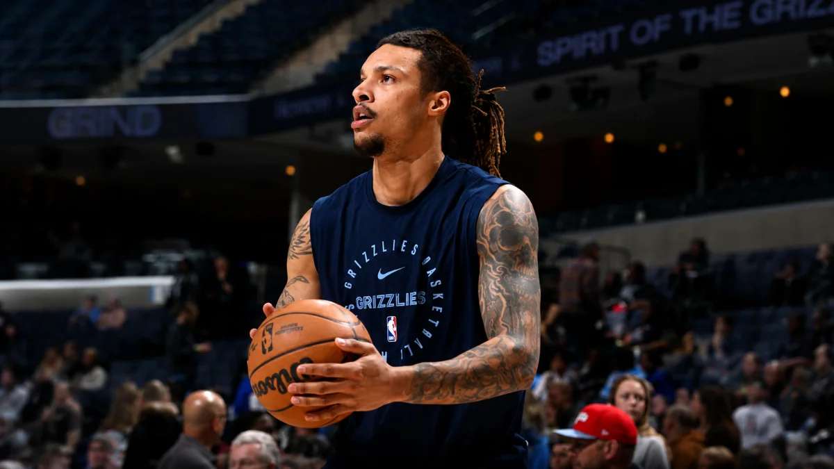 Brandon Clarke holding a basketball during Memphis Grizzlies pre-game warmup on the court in a navy Grizzlies Basketball practice jersey