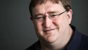 Portrait of Gabe Newell, founder of Steam, wearing glasses and smiling in a studio setting