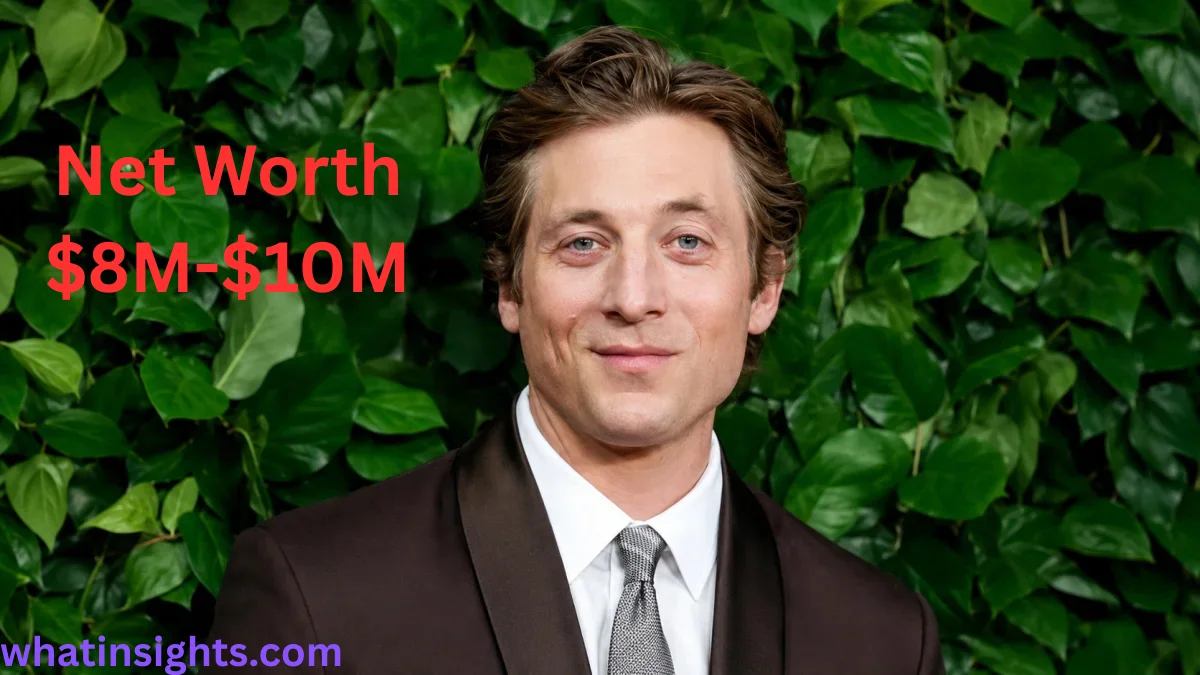 Jeremy Allen White Net Worth portrait image of the actor wearing a formal suit at a public event with a green background.