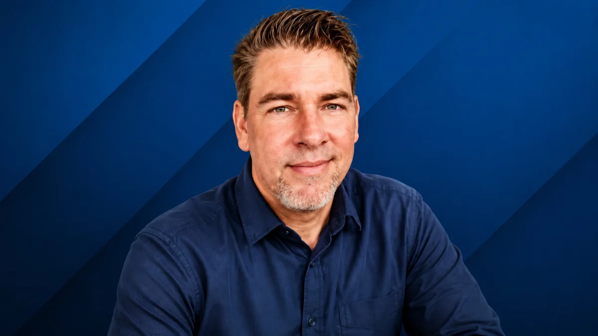 Professional portrait of Kevin Knasel smiling in a blue shirt against a modern background for Kevin Knasel Net Worth related content.