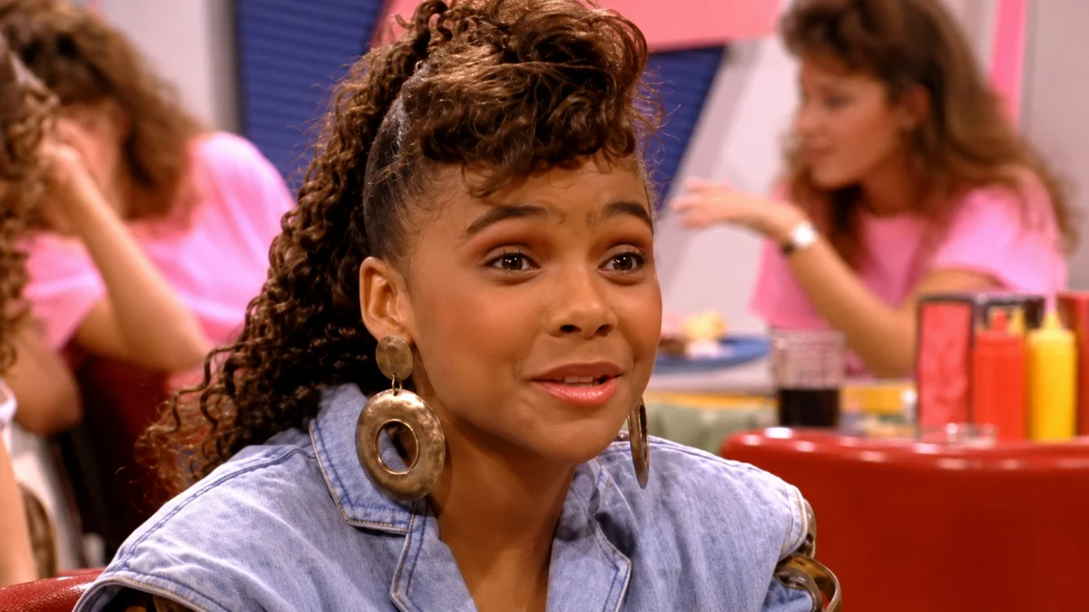 Lark Voorhies as Lisa Turtle smiling in a classic Saved by the Bell television scene with 90s fashion style