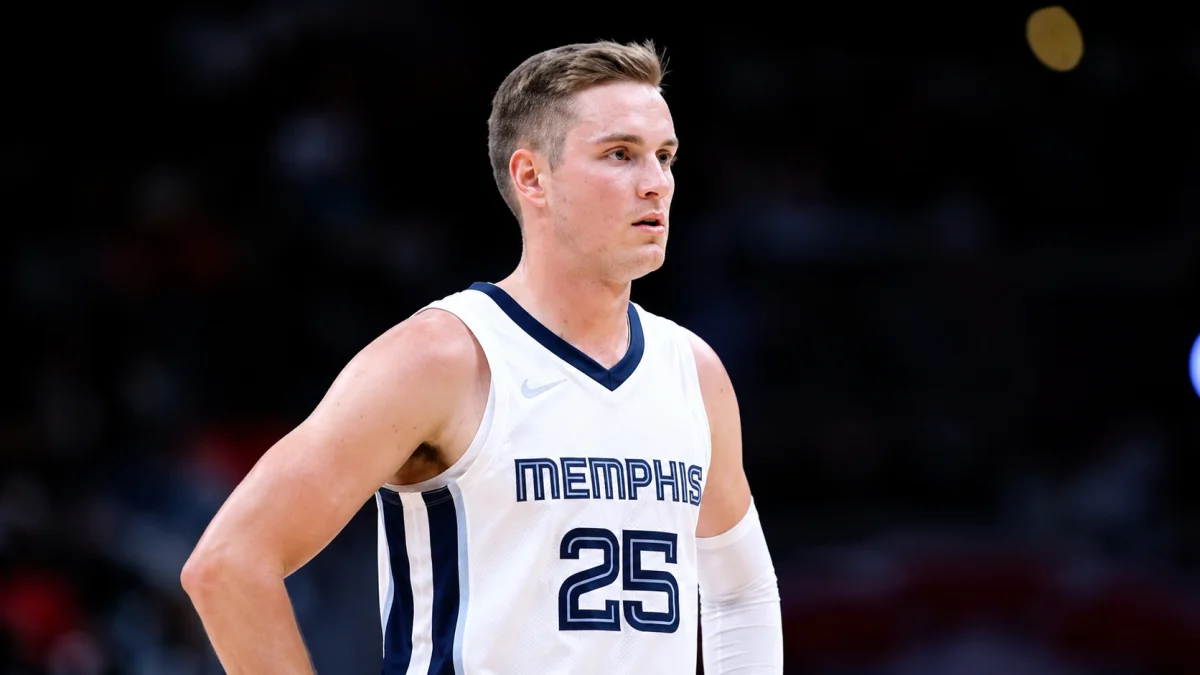 Sam Merrill standing focused during an NBA basketball game while wearing a Memphis jersey inside the arena.