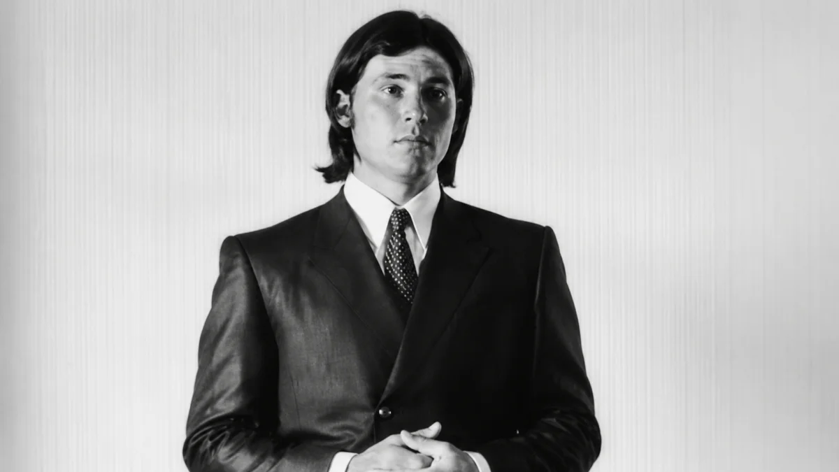 Black-and-white portrait of young Don Baskin wearing a formal suit and tie – Don Baskin Net Worth