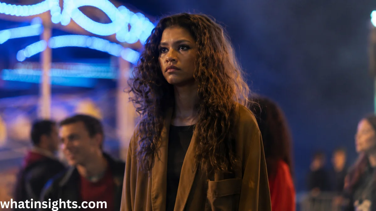 Rue Bennett stands thoughtfully under neon lights in a memorable Euphoria finale scene, reflecting the emotional depth and dramatic ending of the hit HBO series.
