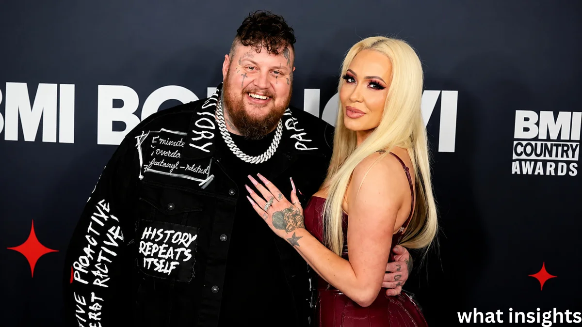 Jelly Roll and his wife posing together at the BMI Country Awards red carpet event, showcasing their stylish outfits and public appearance.