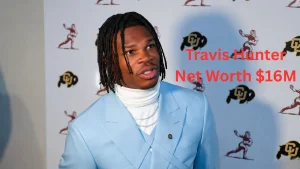 Travis Hunter at a media event in a light blue suit discussing his career achievements and Travis Hunter Net Worth, endorsements, and rising financial success